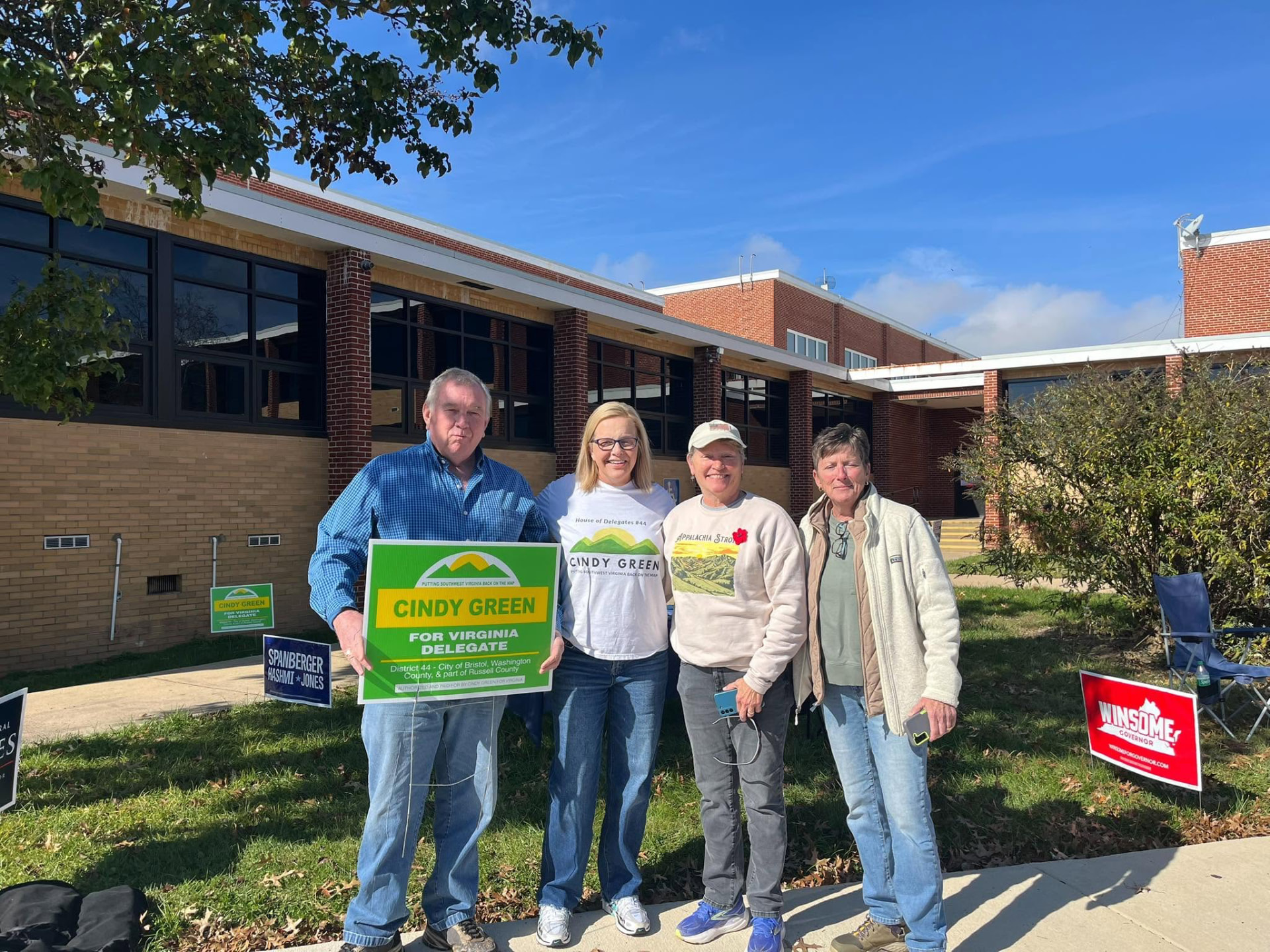 Cindy and supporters holding a Cindy Green for Virginia Delegate yard sign outside a polling place